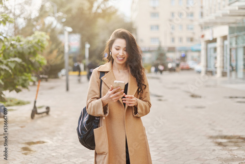 Lifestyle portrait pretty Asian kazakh woman with phone on street