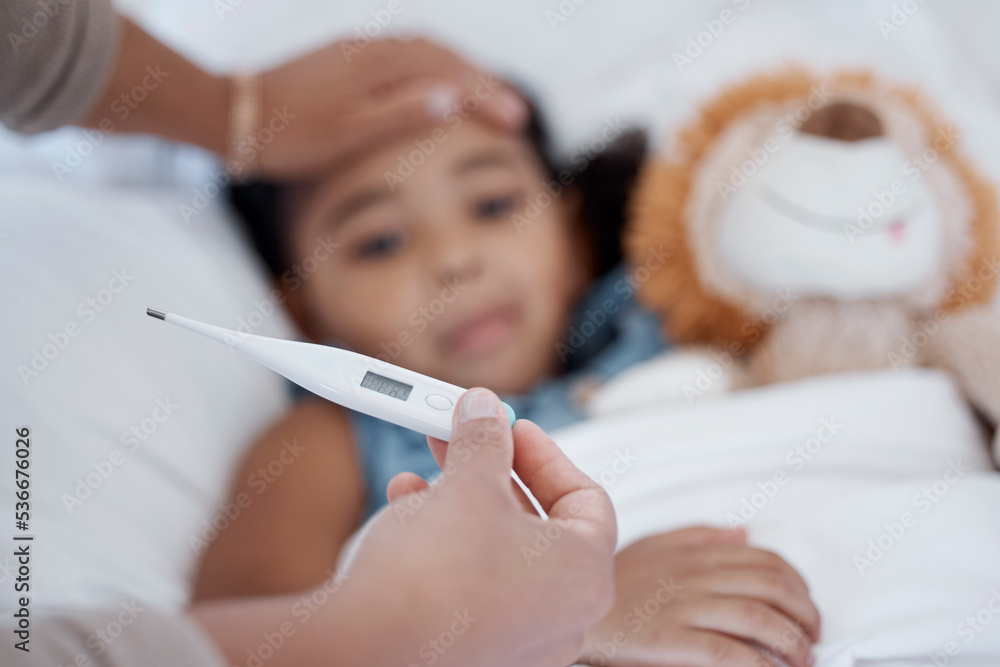 A child in bed with covid, a fever and thermometer showing temperature. Mother with sick kid with hand on head to check if it is hot or cold. Ill with flu, healthcare and medical care in family home A child in bed with covid, a fever and thermometer showing temperature. Mother with sick kid with hand on head to check if it is hot or cold. Ill with flu, healthcare and medical care in family home