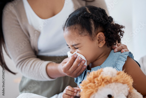 Fotografie Mother clean sick child nose with tissue, playing with toy or teddy bear in bedroom at family home