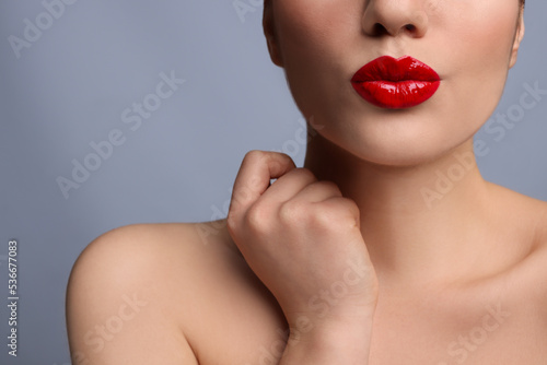 Closeup view of beautiful woman puckering lips for kiss on grey background photo