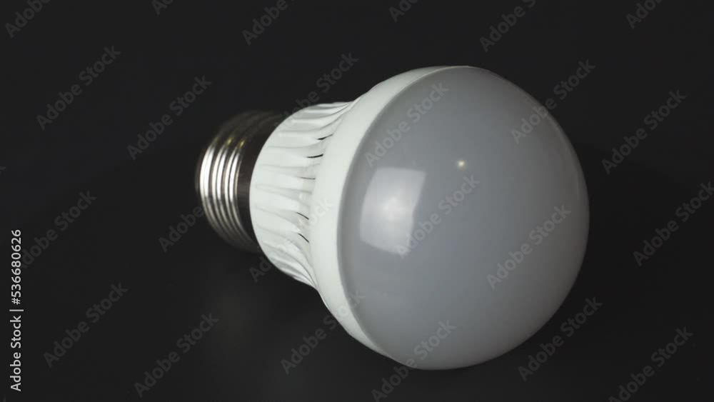 An energy-saving lamp lies on a rotating table. Close-up. Energy saving concept. An energy-saving lamp lies on a rotating table. Close-up. Energy saving concept.