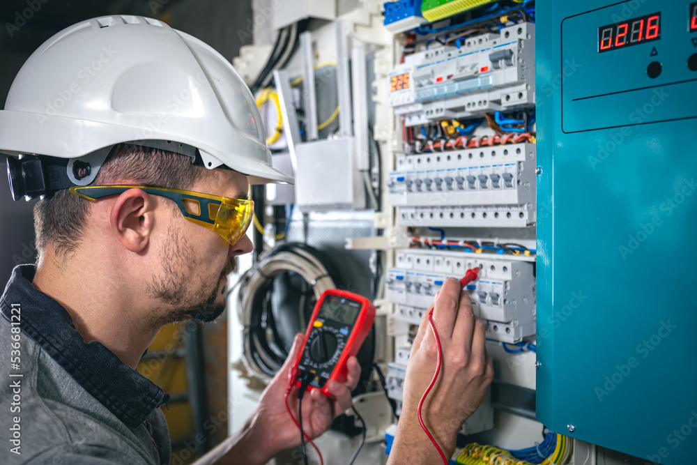 Man, an electrical technician working in a switchboard with fuses. Man, an electrical technician working in a switchboard with fuses.