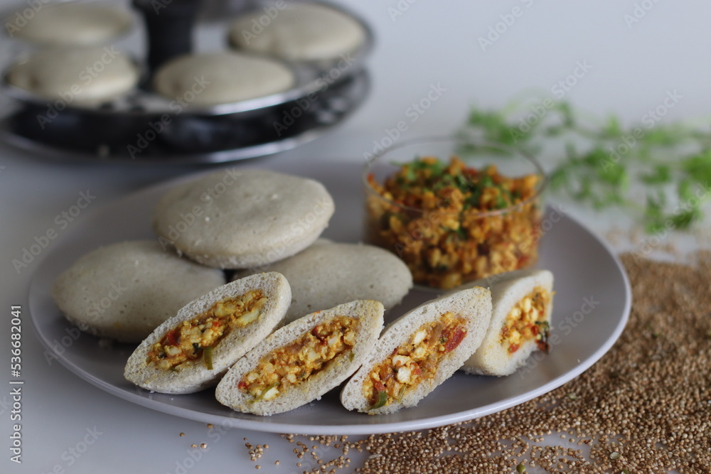 Paneer stuffed kodo millet Idly. Steamed savory cakes made of kodo millets and lentil flour stuffed with a patty made of scrambled cottage cheese with onions and tomatos