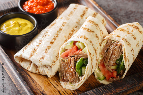 Tableau sur toile Doner kebab or shawarma with beef and fresh vegetables closeup on the wooden board on the table