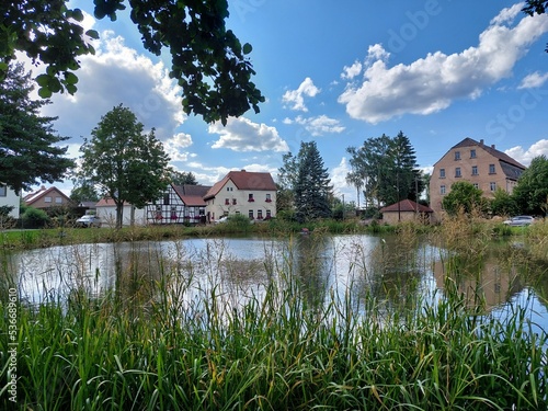 Teich im Dorf mit schöner Umgebung und bedecktem Himmel