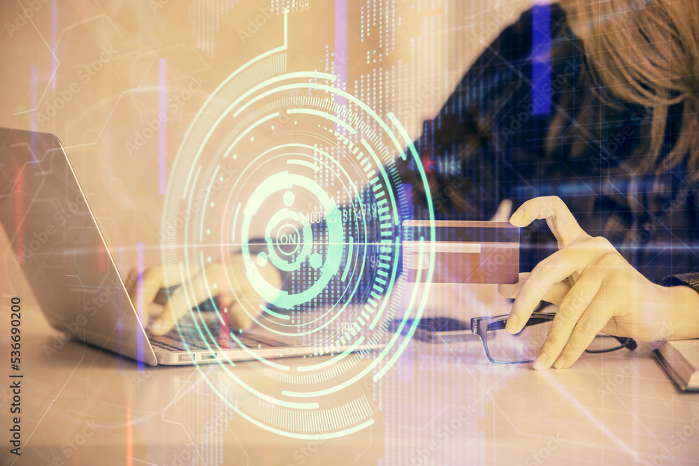 Double exposure of woman on-line shopping holding a credit card and data theme hologram drawing. E-commerce concept. Double exposure of woman on-line shopping holding a credit card and data theme hologram drawing. E-commerce concept.