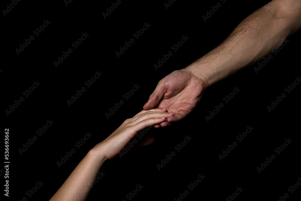 Gentle touch of female and male hands on a black background. Gesture expressing love and tenderness
