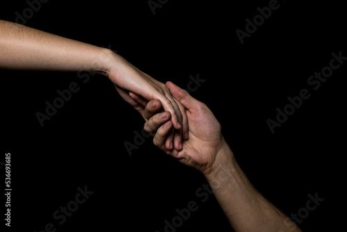 Gentle touch of female and male hands on a black background. Gesture expressing love and tenderness