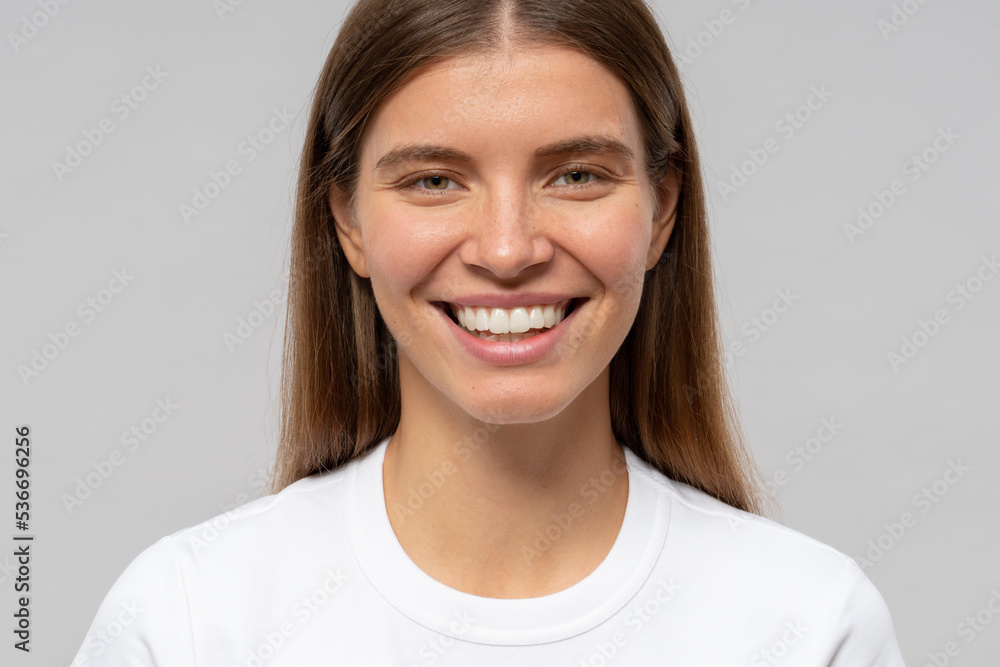 Close-up portrait of woman with toothy smile isolated on gray studio background Close-up portrait of woman with toothy smile isolated on gray studio background