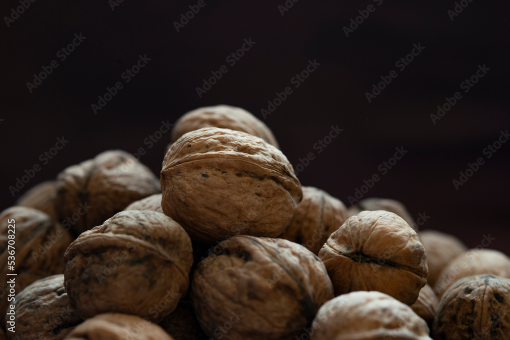 Bowl full of walnuts on black background with copy space Bowl full of walnuts on black background with copy space
