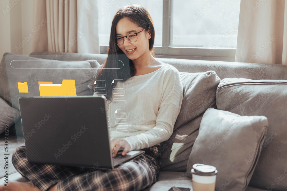 Naklejka premium Asian woman working with laptop from home. businesswoman smiling and working electronic documents on computer in living room.
