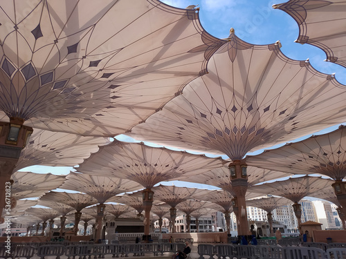 Medina, Saudi Arabia - October 07, 2022: Umbrella construction on the square of Al-Masjid An-Nabawi or Prophet Muhammed Mosque are protecting people from sun at daytime and work as lights at night