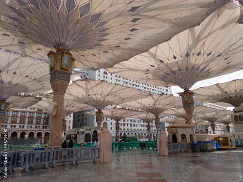 Medina, Saudi Arabia - October 07, 2022: Umbrella construction on the square of Al-Masjid An-Nabawi or Prophet Muhammed Mosque are protecting people from sun at daytime and work as lights at night photo