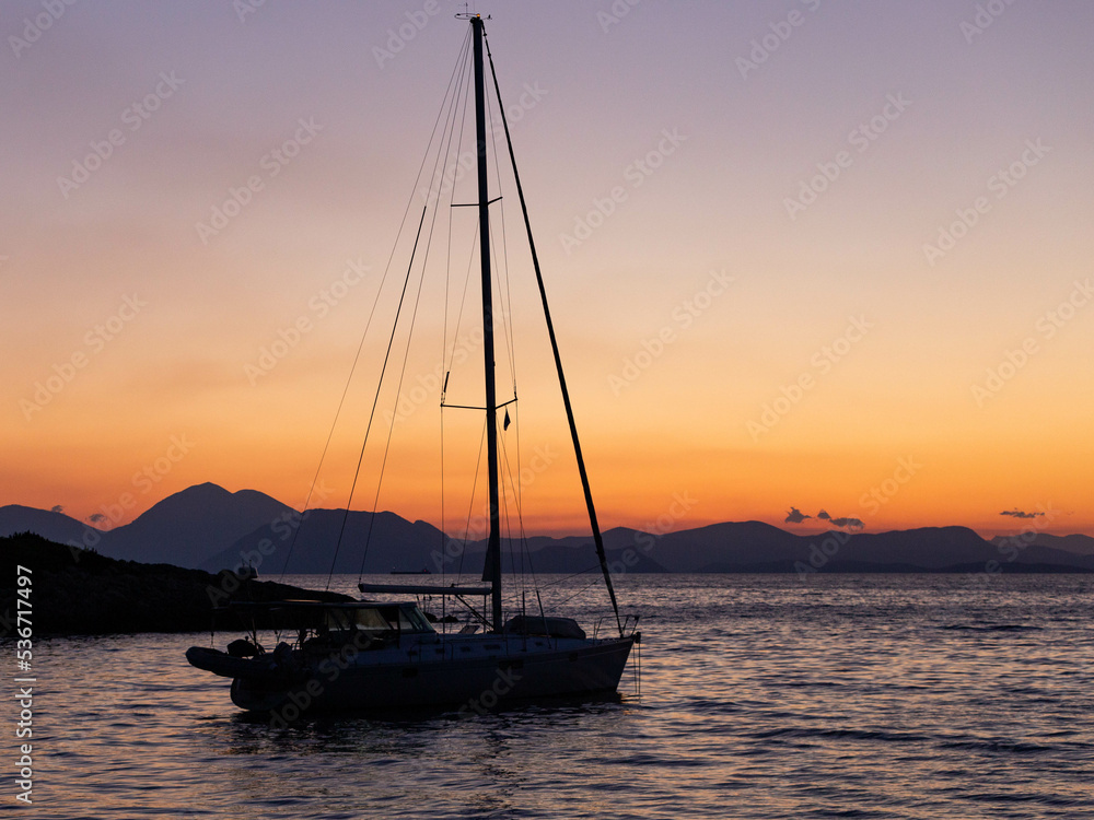 sailboat in the sea at sunrise