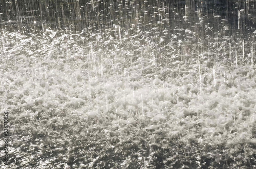 Fényképezés Large drops of rain fall into a puddle of water