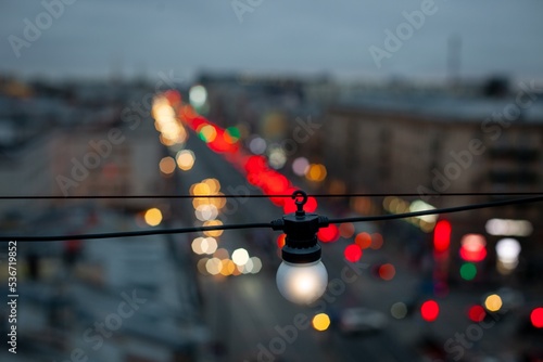 Obraz na płótnie A white light bulb over the city's night avenue w salonie