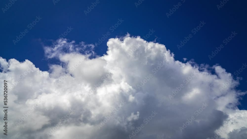 Time lapse of moving white clouds against deep blue sky