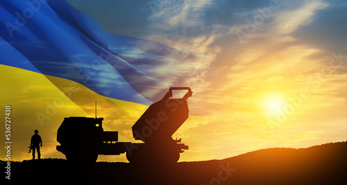 Artillery rocket system are aimed to the sky and soldier at sunset with Ukrainian flag. Multiple launch rocket system. 3d-rendering. © hamara