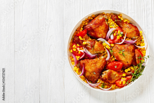 roast chicken with corn and tomatoes on plate