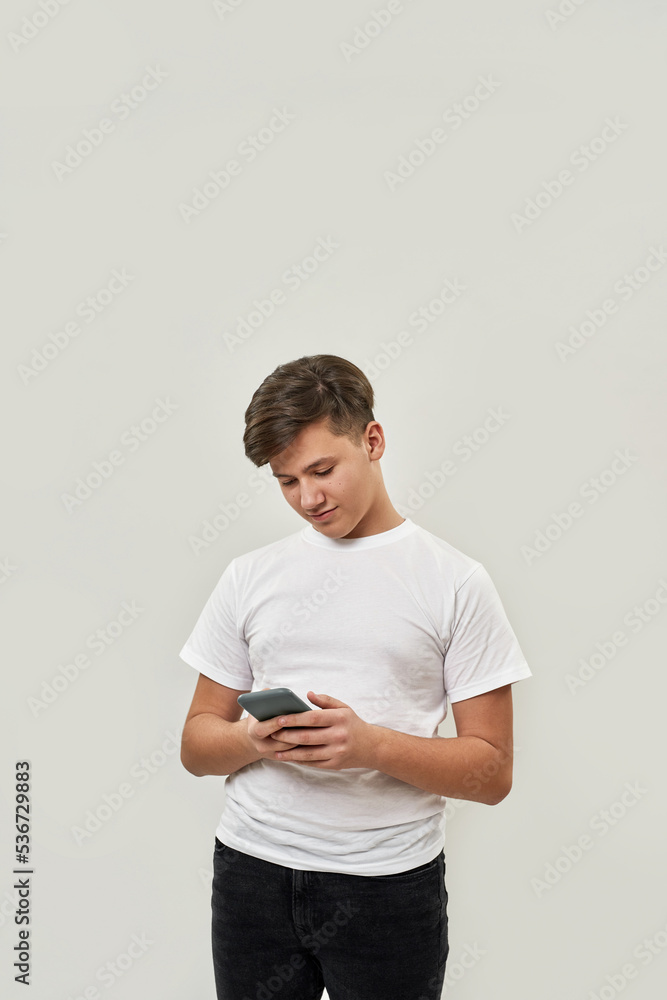 Caucasian teenage boy using smartphone in hands Caucasian teenage boy using smartphone in hands