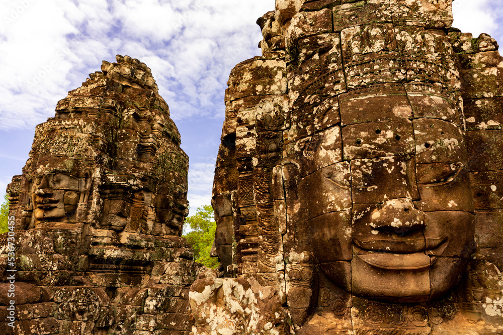 Human stone face heads at Bayon Temple in archeologic site at Angkor Temples in Cambodia