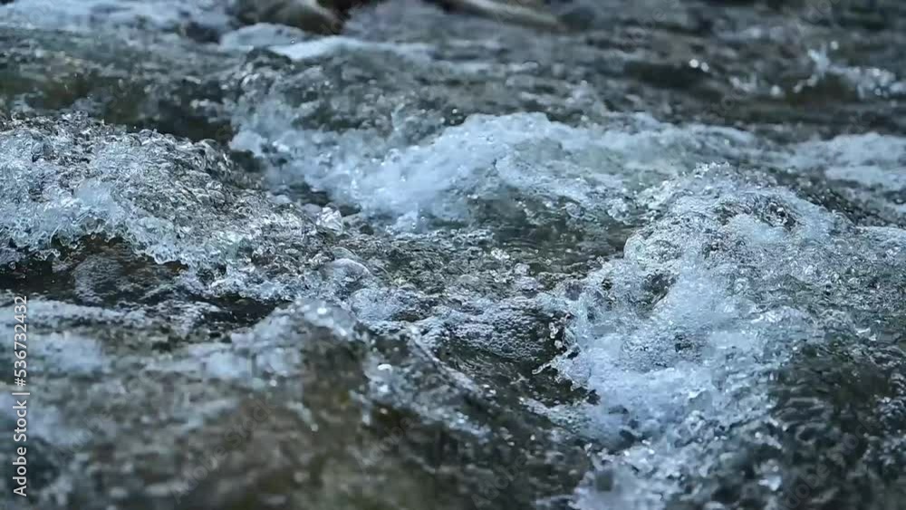a mountain river flowing through stone rapids in the Carpathians at a slow pace, a stream of water in slow motion. a mountain river flowing through stone rapids in the Carpathians at a slow pace, a stream of water in slow motion.