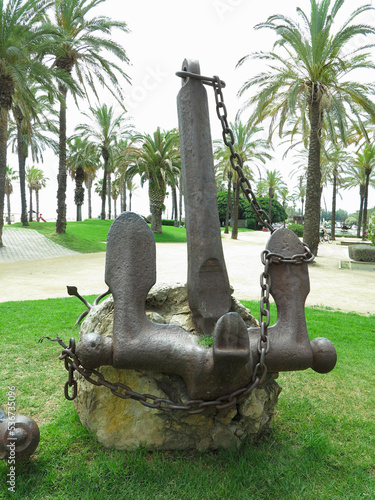 TARRAGONA, SPAIN - 06.07.2022: Iron black old rusty naval anchor monument in parc photo