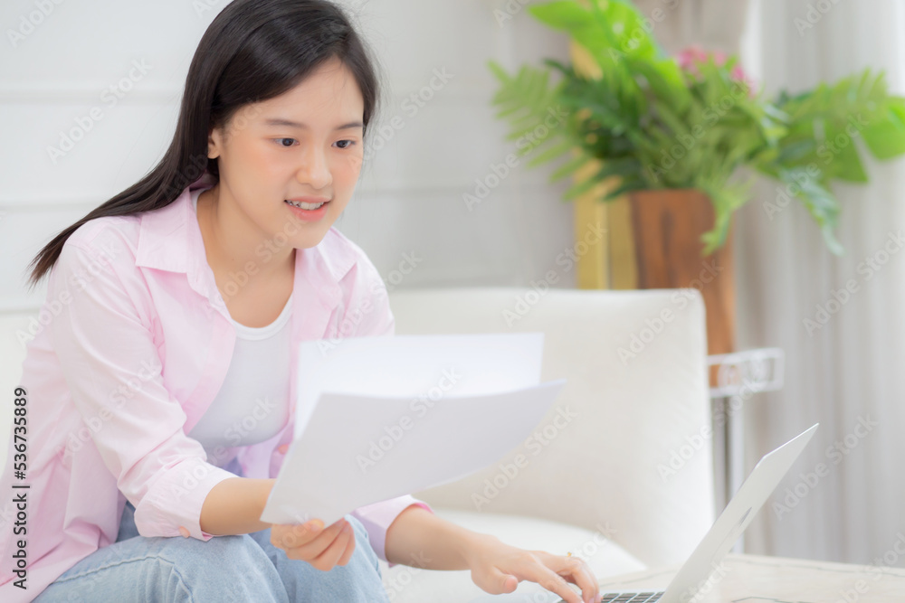 Young asian business woman working on laptop computer and looking graph and chart of report for profit on paper at home, businesswoman looking investment and income, data of infographic statistics. Young asian business woman working on laptop computer and looking graph and chart of report for profit on paper at home, businesswoman looking investment and income, data of infographic statistics.