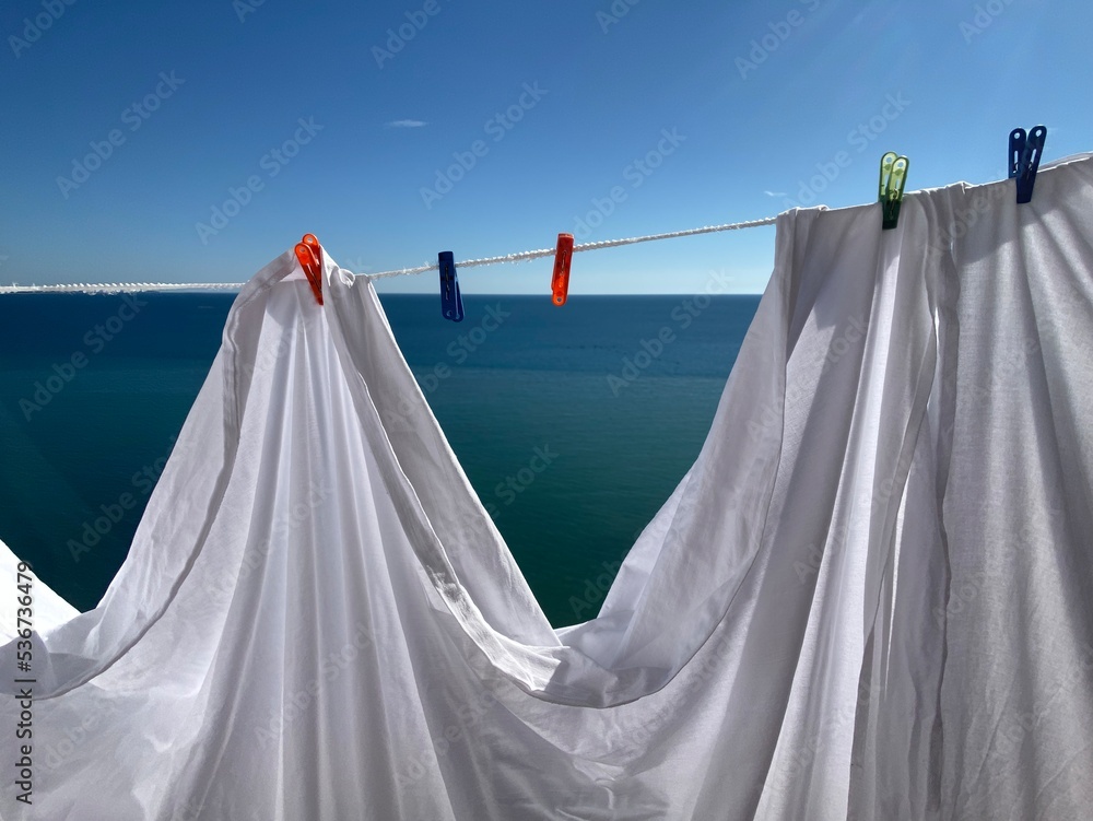 clothes drying on the rope with pins at sea horizon background clothes drying on the rope with pins at sea horizon background