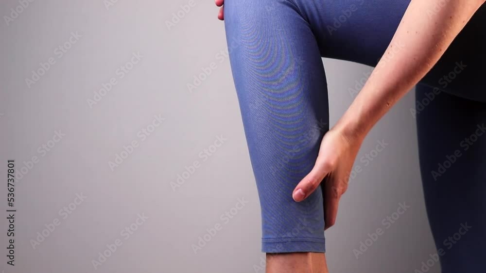 Shin pain, ache. Calf muscle strain, cramp. Hand massaging painful leg