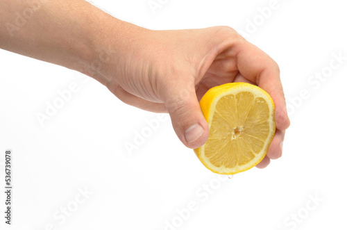 human hand squeezing lemon large pan on white background