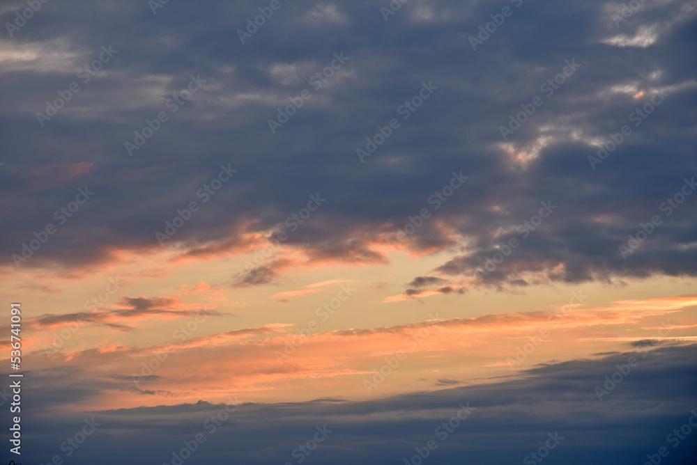 Fototapeta premium Sunset sky with pink and blue clouds in summer. Beautiful sunset with the sun.