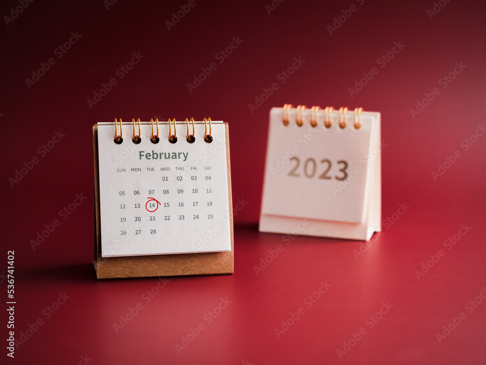 Happy Valentine's day, February 2023 calendar desk on red background. Red circle draws hand mark on day 14 on white table calendar with the February month near white cover with the 2023 year numbers. Happy Valentine's day, February 2023 calendar desk on red background. Red circle draws hand mark on day 14 on white table calendar with the February month near white cover with the 2023 year numbers.