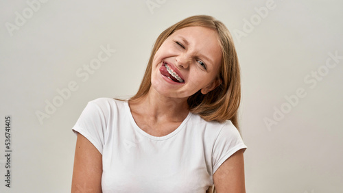 European teenage girl wink and stick out tongue