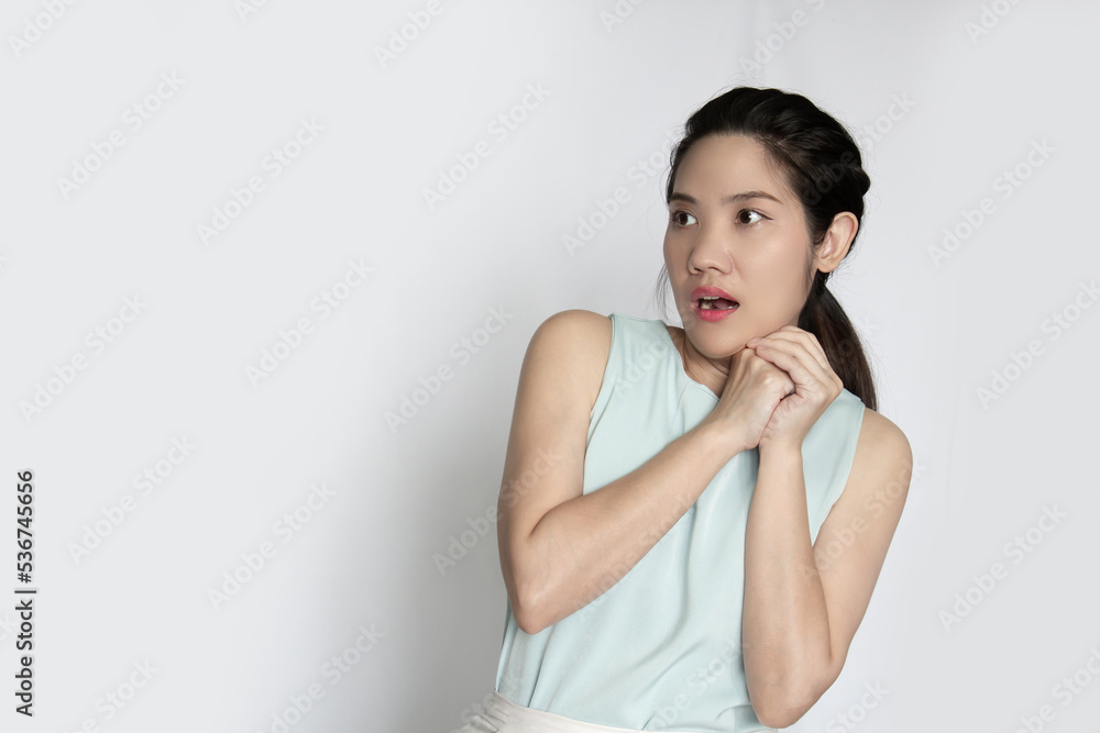 Asian beautiful woman holds her both hand and looking above with surprised face Asian beautiful woman holds her both hand and looking above with surprised face