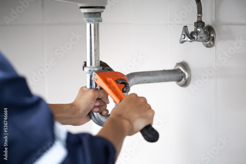 Photographie plumber at work in a bathroom, plumbing repair service, assemble and install concept