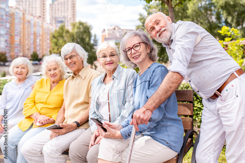 Group of seniors people bonding at the park - Elderly old friends social gathering and spending time together outdoors
