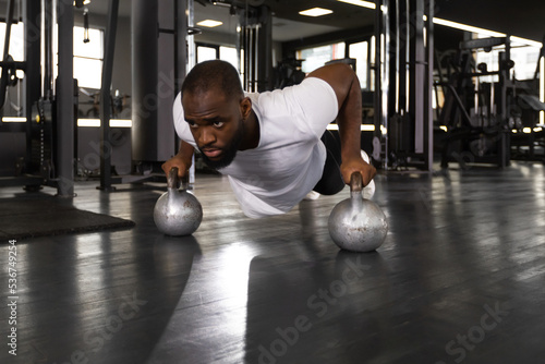 Sporty african man doing push-up in a gym.