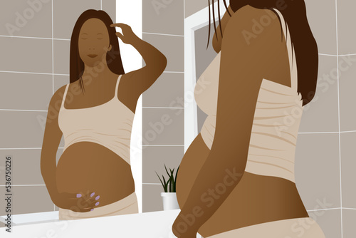 Beautiful pregnant woman, african american woman with dark skin and dark hair, expectant mother hugging her belly with her hands