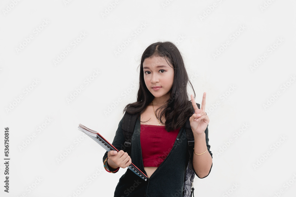 A second year college student holds up two fingers as she poses for a studio shot isolated on a white background. Peace sign hand gesture. A second year college student holds up two fingers as she poses for a studio shot isolated on a white background. Peace sign hand gesture.
