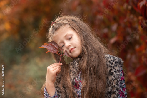 a girl with leaf  in her hand in autumn park