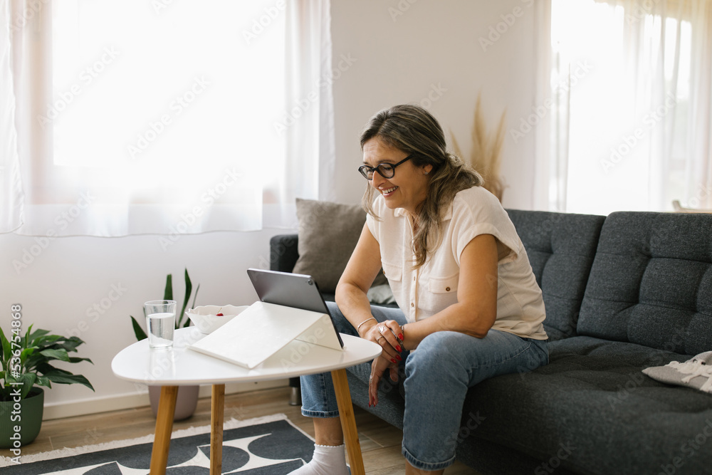 Adult woman having video call at home using tablet Adult woman having video call at home using tablet