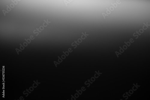 Dark black and gray blurred gradient background has a little abstract light.