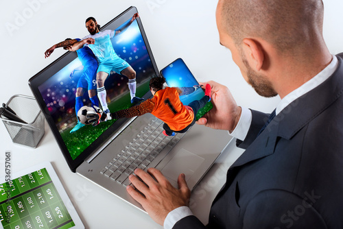 Businessman watches football match and bets on soccer website photo