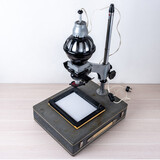 Antique photographic enlarger (1967) with a case as object table.