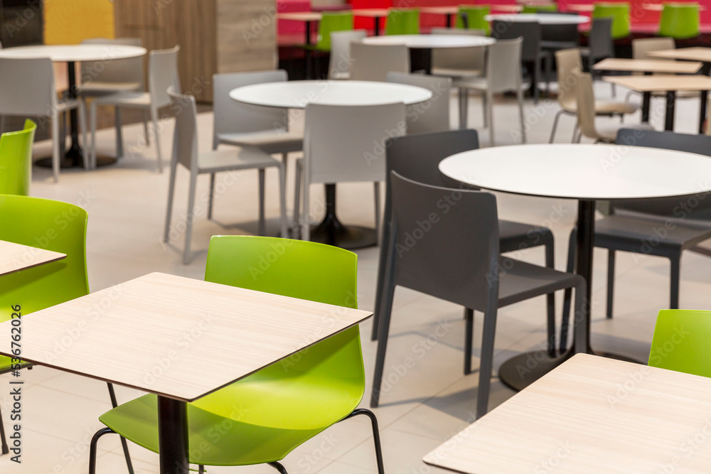 Empty tables and comfortable seating at a food court in a shopping mall.