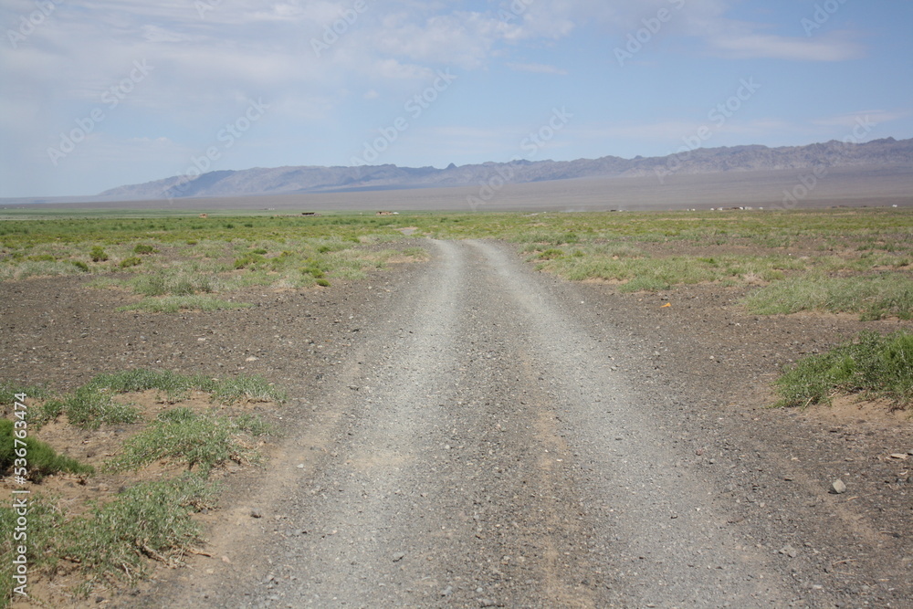 The lonely road in the Gobi Desert, Umnugovi, Mongolia. It is sandy and dusty. During the long winter months, the road is covered with the snow.