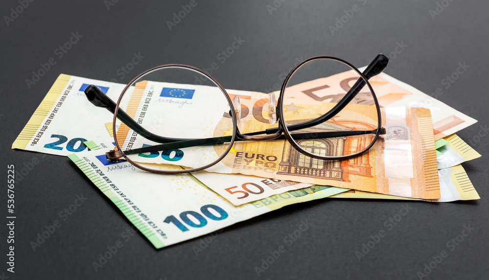 Eye glasses with euro bills on black background. Business concept. Eye glasses with euro bills on black background. Business concept.