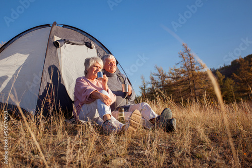 Camping tent vacation Senior couple man and woman sitting near camp tent