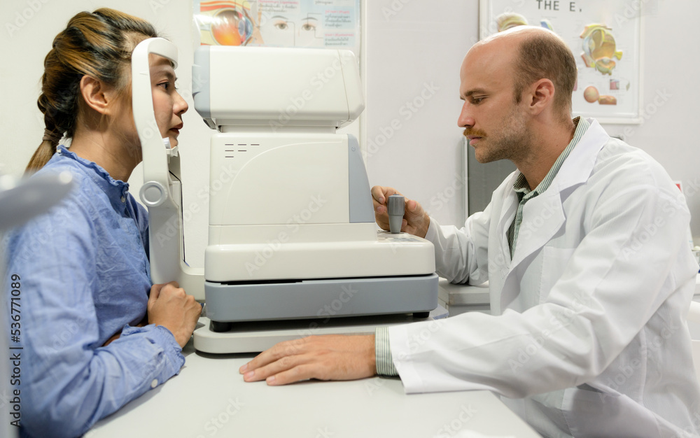 A young woman checks her eyes with an optometrist. A young woman checks her eyes with an optometrist.